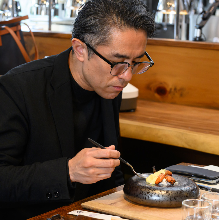 ニンジン料理を口にする田村氏