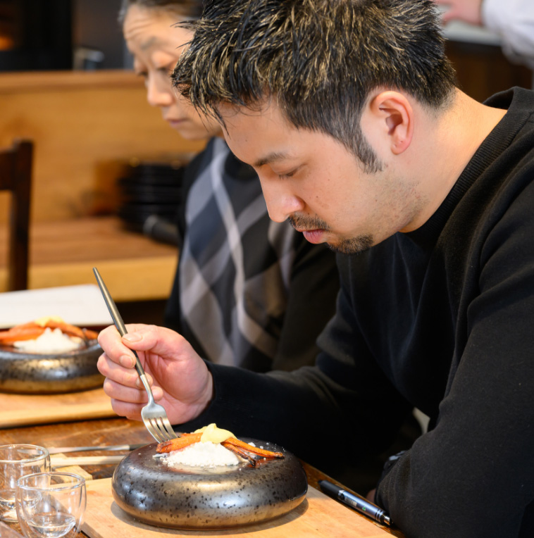 ニンジン料理を口にする大津氏